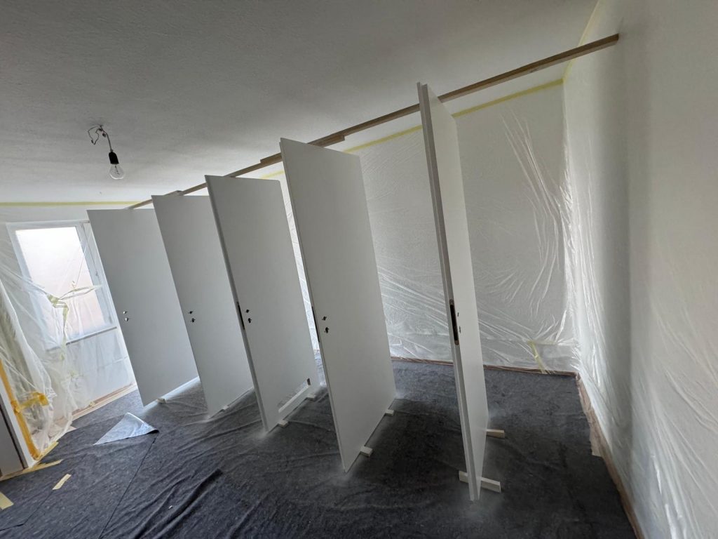 Weiß lackierte Türen nach frischer Lackierung im vorbereiteten Raum