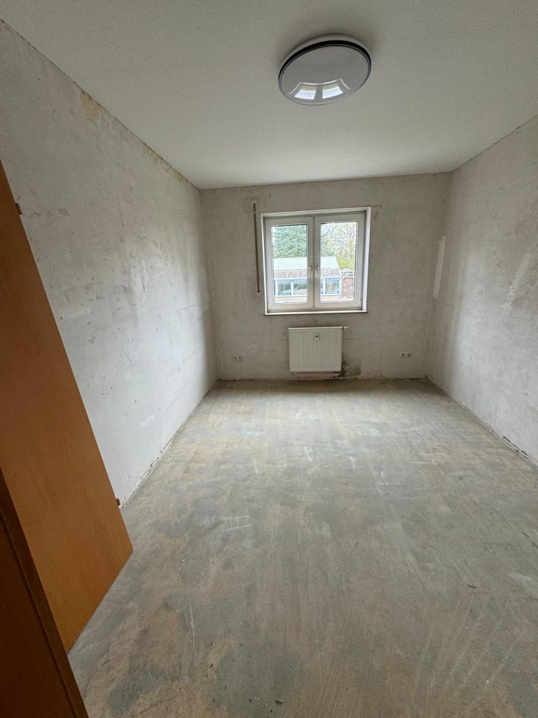 Leerer Raum mit kahlen Wänden und vorbereitetem Boden für Malerarbeiten