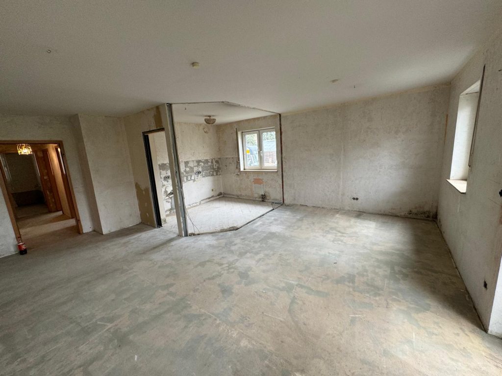 Wohnbereich mit offenen Wänden und sichtbaren Vorbereitungen für Renovierungsarbeiten